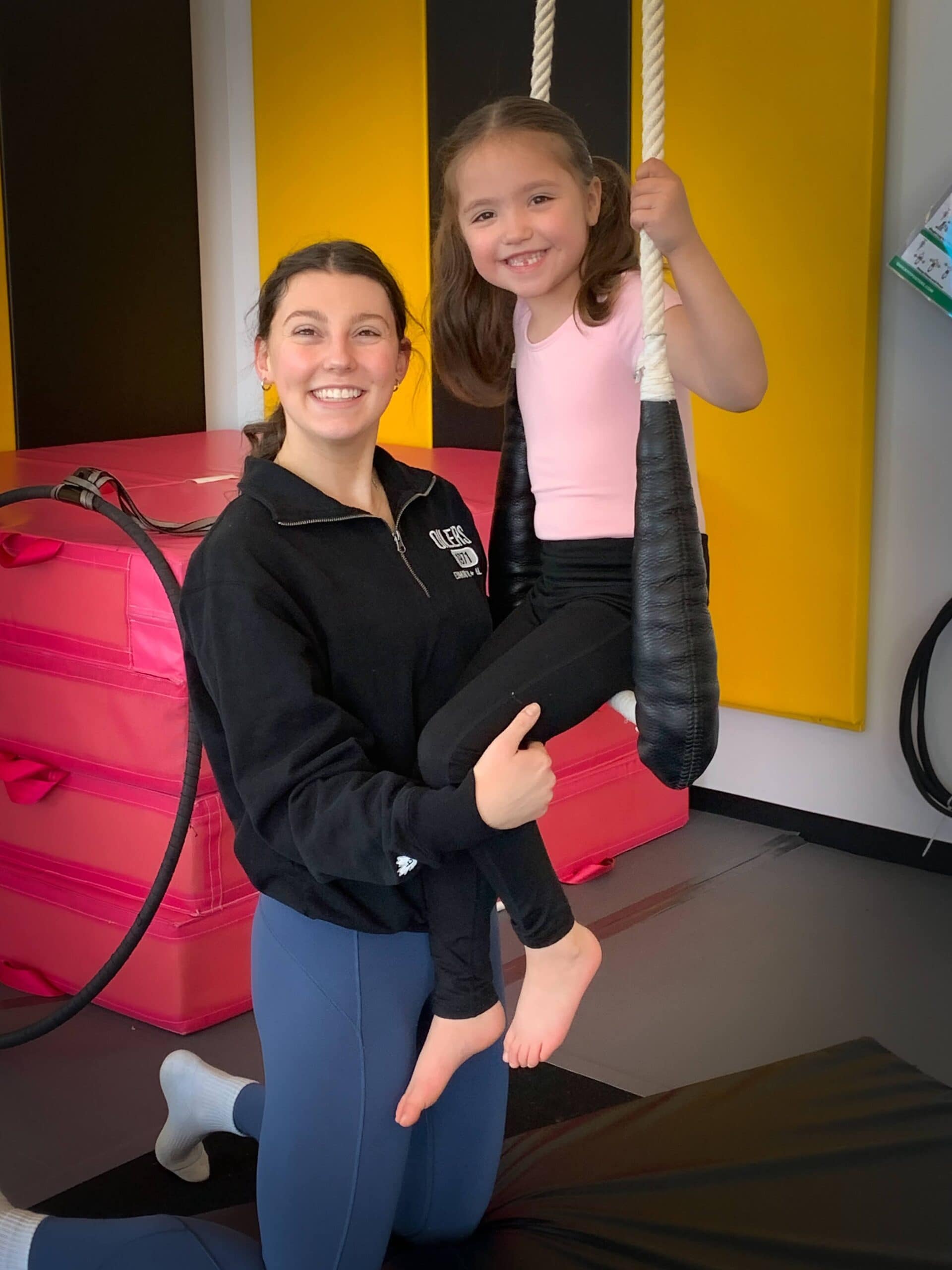 coach assisting student in static trapeze