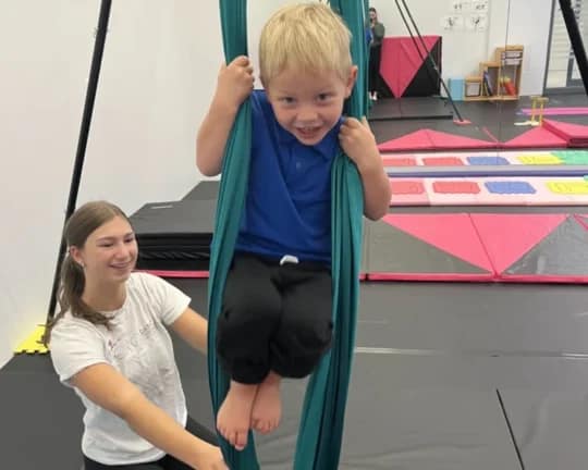 Student on aerial silk at a summer camp